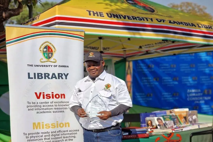 Chief Librarian Dr Banda displaying the award